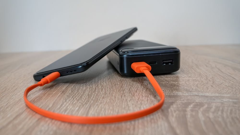 smartphone charging on a wooden surface